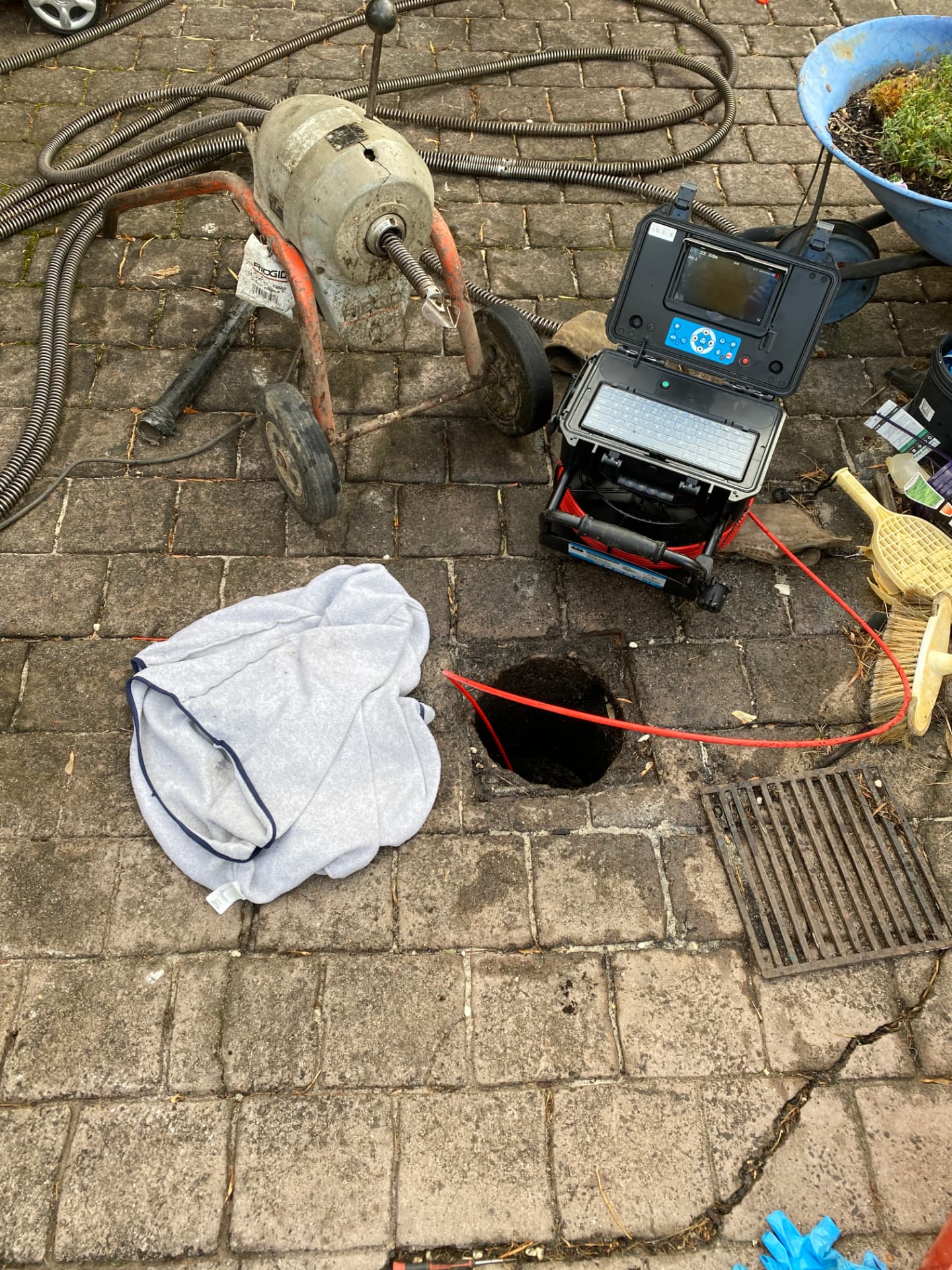Drain machine and CCTV camera reel set up beside an open drain inspection point