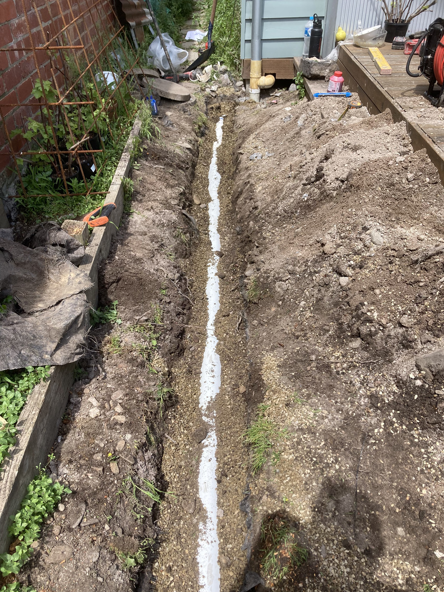 Excavated trench with new pipework bedded in gravel